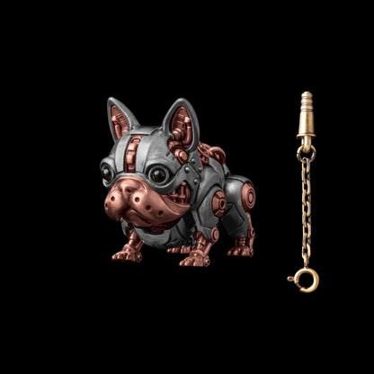 A silver-tone mechanical dog figure with reddish details beside a key on a chain.